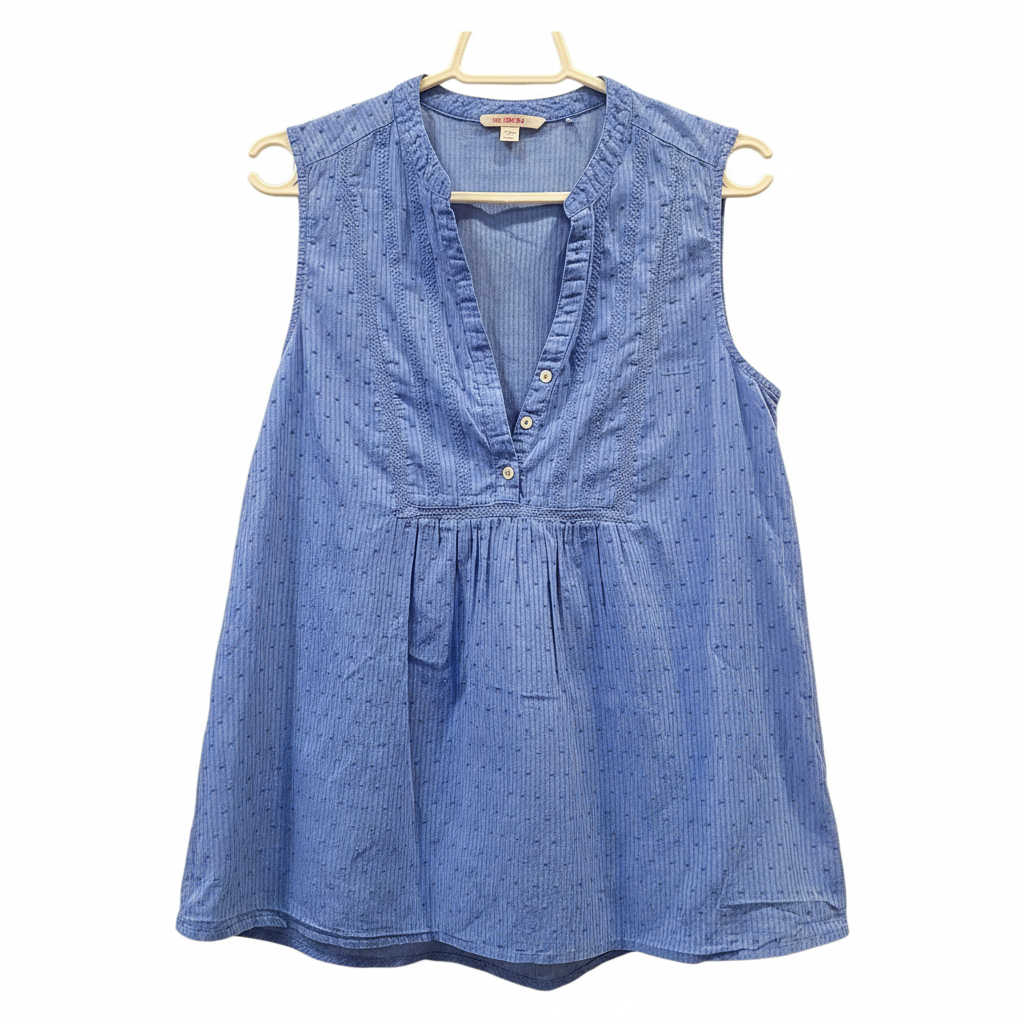 Blusa azul sin mangas encaje cuello V planchada fondo blanco