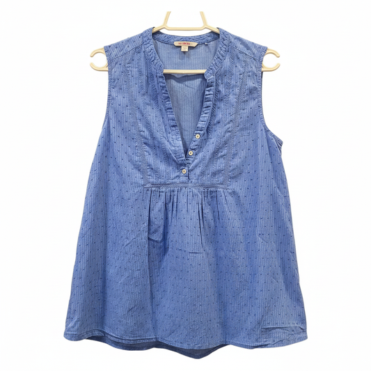 Blusa azul sin mangas encaje cuello V planchada fondo blanco