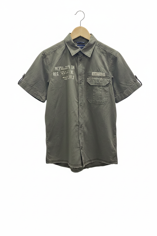 Camisa militar manga corta verde oliva khaki con parches bolsillo con solapa estilo vintage planchada en percha